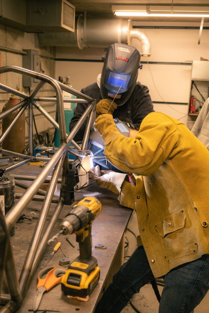Highlander Racing student welding a steel frame in the workshop